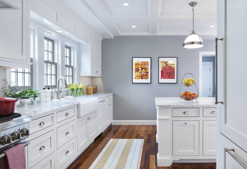 Farmhouse sink, coffered ceilings, and cumaru brazilian teak floors adorn this transitional kitchen in Hopkins, MN.