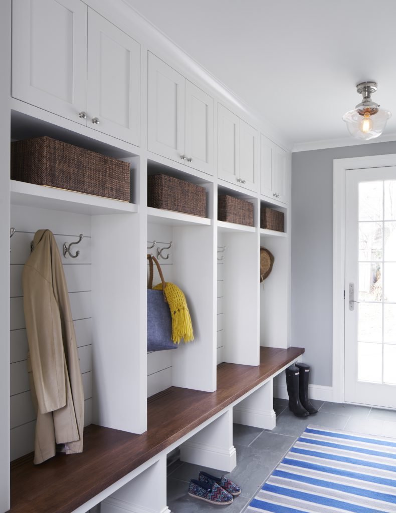 The mudroom has cubbies, storage hooks, shelving, and custom cabinetry.